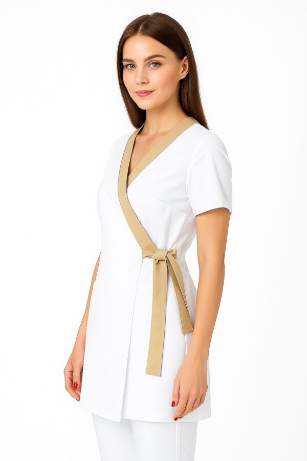 Elegancki biały uniform kosmetyczny dla kobiet z beżową lamówką i wiązaniem, idealny dla kosmetologów i personelu medycznego.